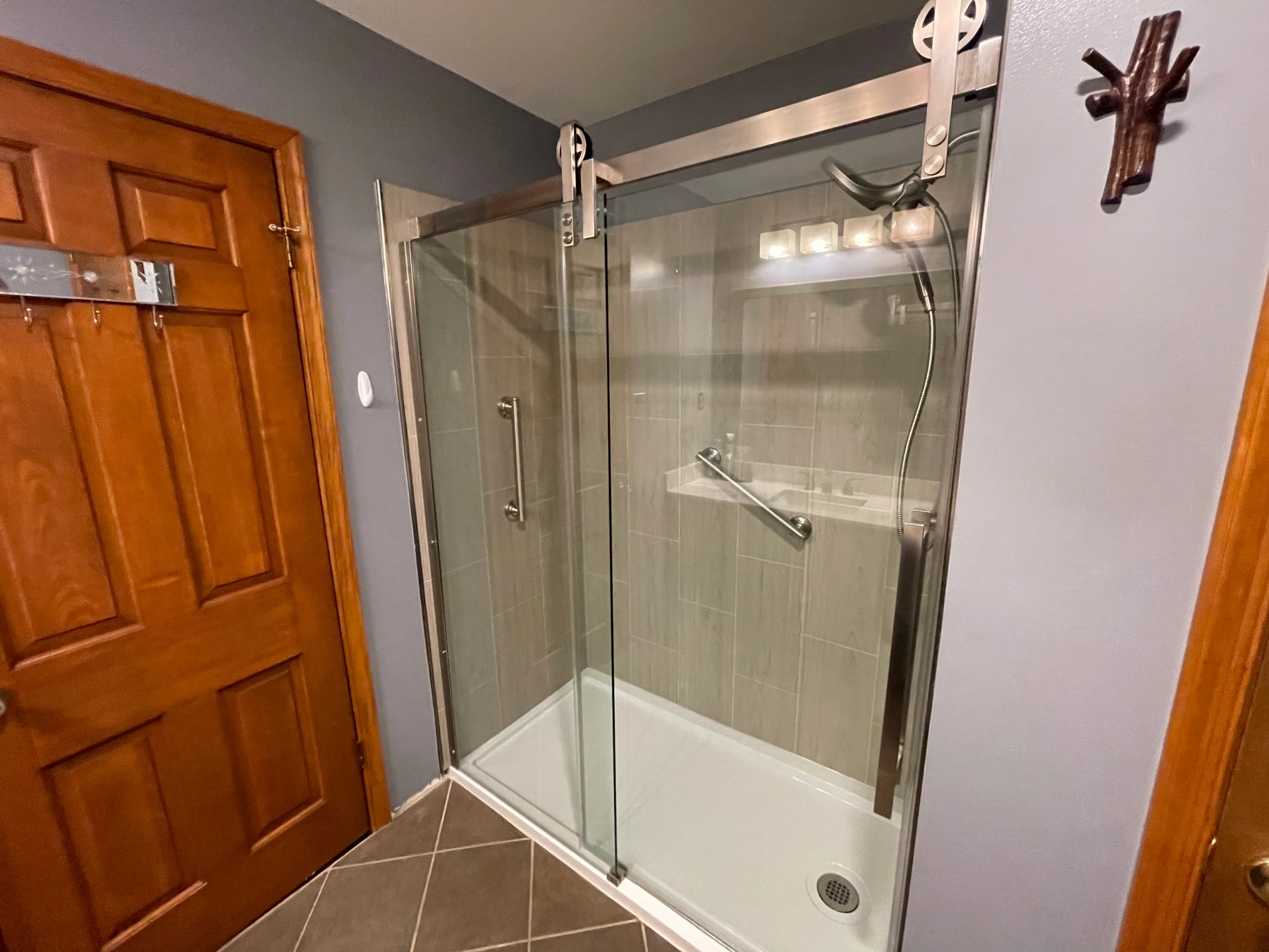 Remodelled bathroom with a tiled shower surround and a frameless sliding glass door