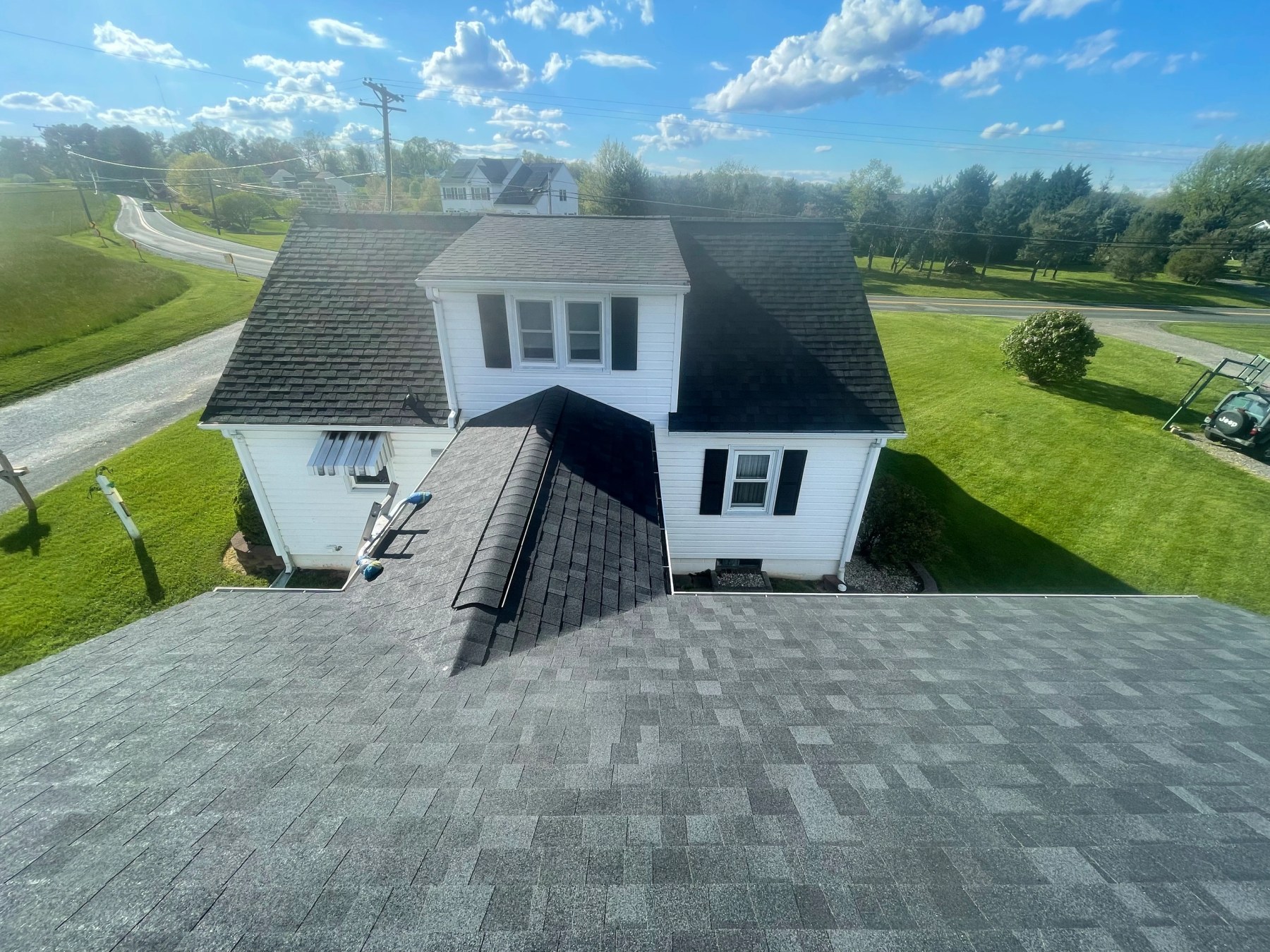 Second view of a completed roof replacement showing new shingles and flashing